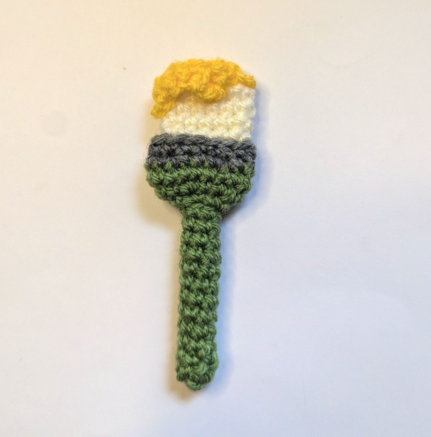 Finished paint brush charm — green handle, white ferrule, and a yellow bristle tip