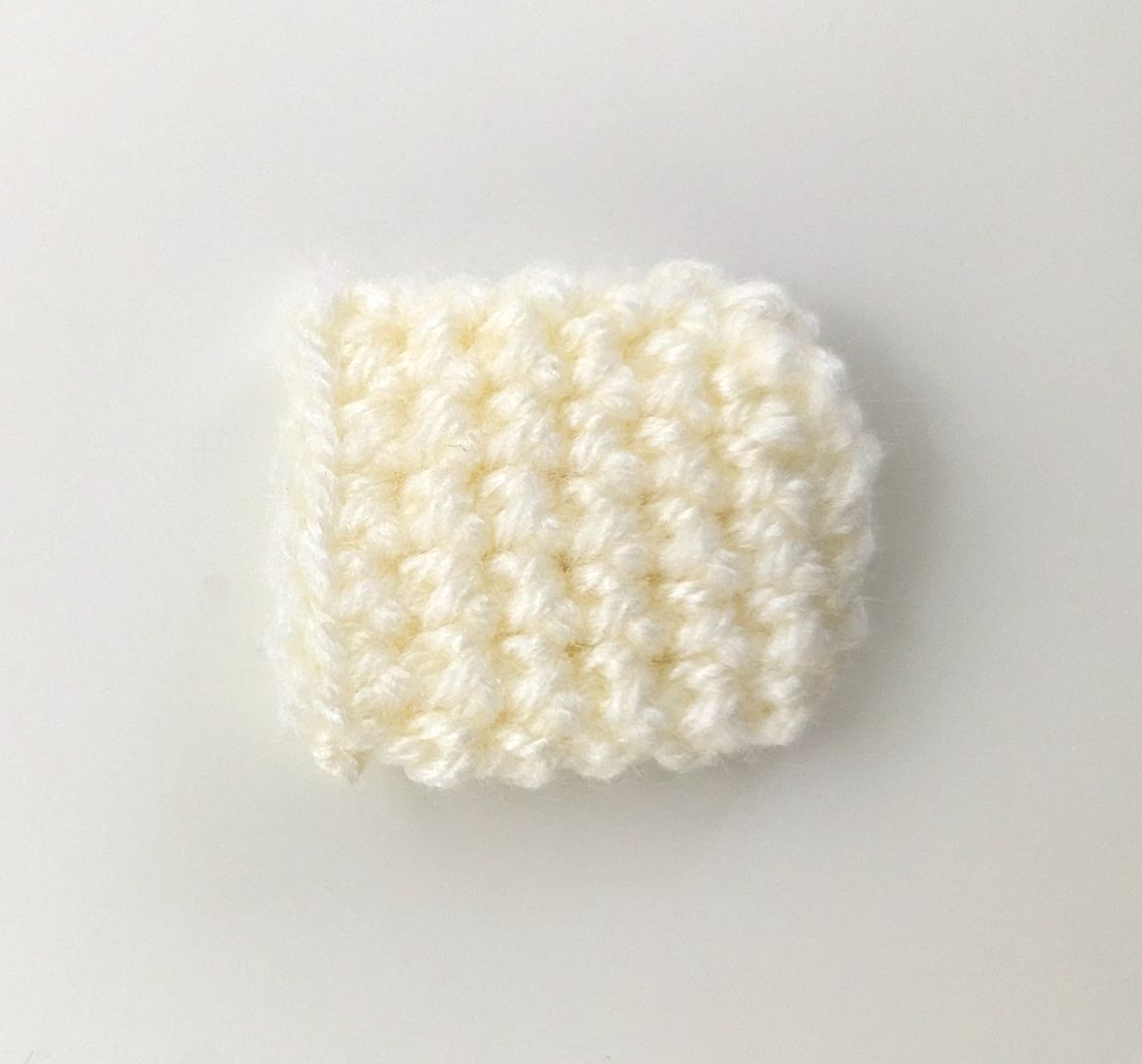 Small cream-colored crocheted oval piece for the brush bristles