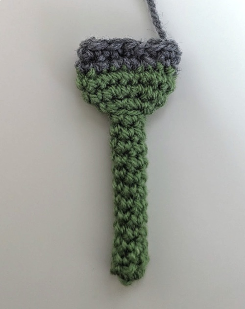 Finished crocheted brush handle — a green tube with a gray top band