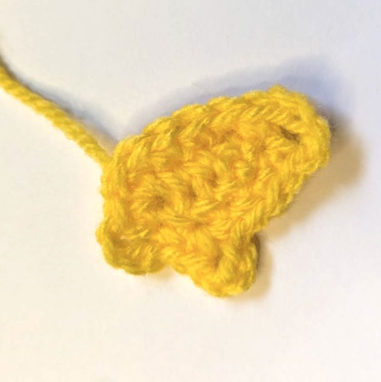 Small yellow crocheted paint drip piece with three loopy chain accents