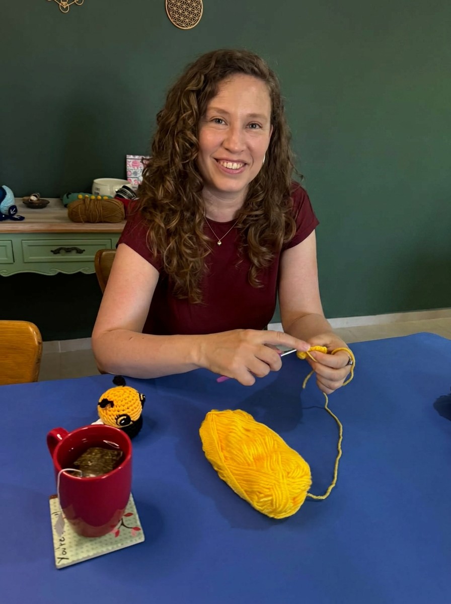 Mor Naveh, maker behind Artbygng, crocheting with a cup of tea