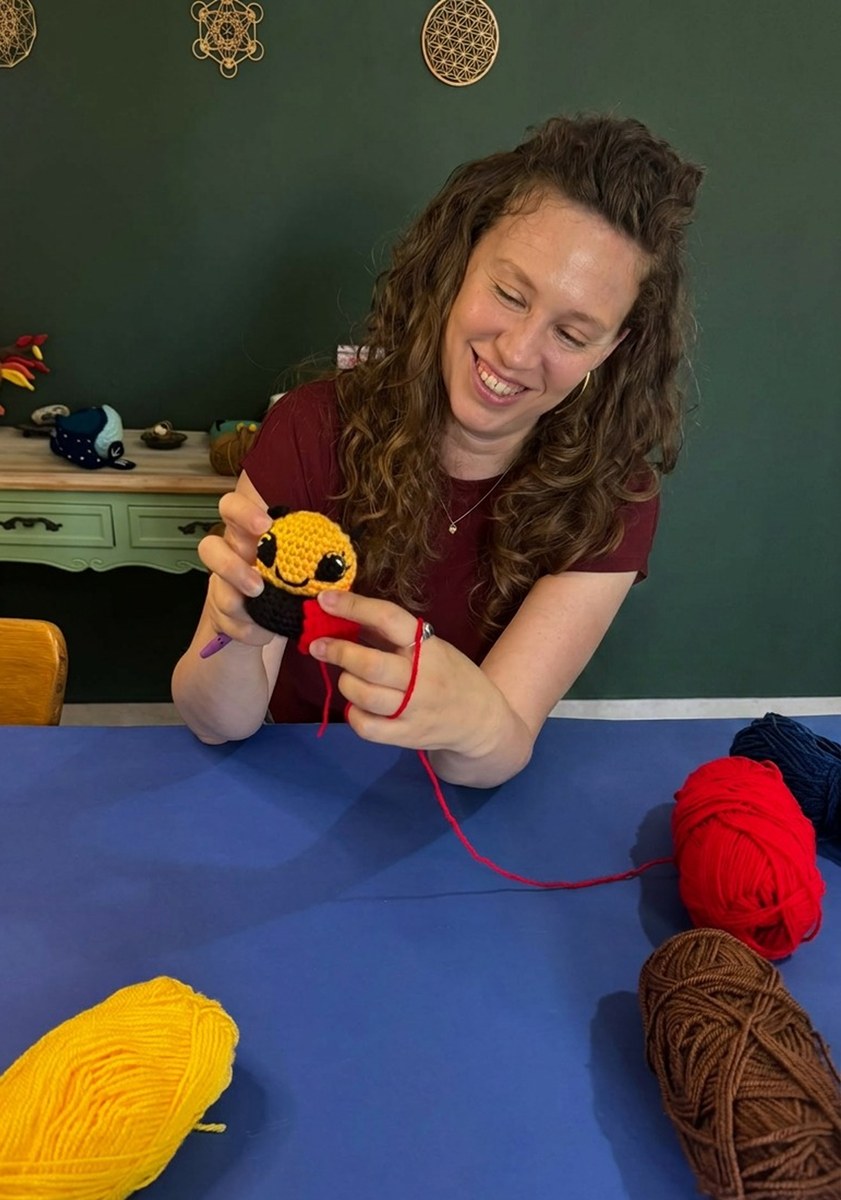 Mor Naveh, maker behind Artbygng, crocheting a bee amigurumi